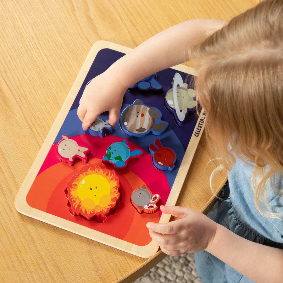 Child playing with a colorful wooden puzzle on a wooden table