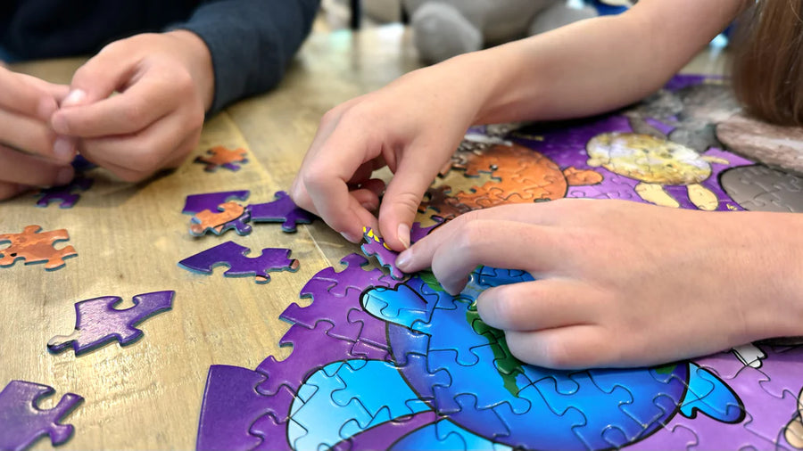 Children playing with a puzzle on a wooden table